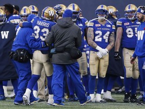 Blue Bombers running back Andrew Harris (33) is helped off the field after getting hit and injured in Saturday's game against the Lions in WInnipeg. THE CANADIAN PRESS/John Woods