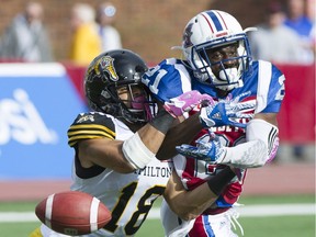 Montreal Alouettes' Michael Carter, right, is tackled by Hamilton Tiger Cats' Junior Collins during first half CFL football action in Montreal, Sunday, October 22, 2017.