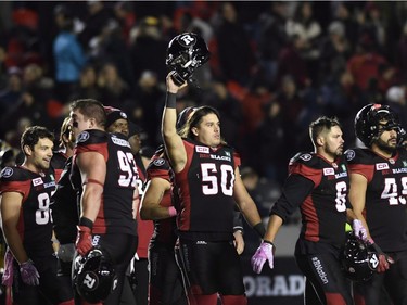 Redblacks long snapper Louis-Philippe Bourassa (50) holds up his helmet as the team celebrates winning against the Tiger-Cats on Friday. THE CANADIAN PRESS/Justin Tang