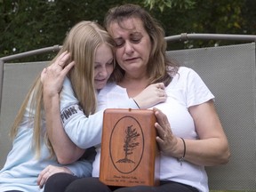 Denise Lane and her daughter Megan sit with the urn containing the ashes of her son Shawn who died of a fentanyl overdose in Innisfil, Ont., about an hour's drive north of Toronto.