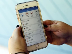 In this Tuesday, Aug. 1, 2017, photo, Jen Vargas looks at a call log displayed via an AT&T app on her cellphone at her home in Orlando, Fla. The app helps locate and block fraudulent calls although some robocalls still get through. (AP Photo/John Raoux)