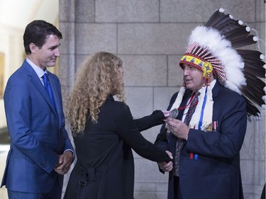 Assembly of First Nations Chief Perry Bellegarde, right, shows Governor general-designate Julie Payette a medal as they shakes hands, as Prime Minister Justin Trudeau looks on, before Payette's installation as Canada's 29th Governor General, on Parliament Hill in Ottawa on Monday, Oct. 2, 2017.