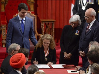 Canada's 29th Governor General Julie Payette signs her official instruments as Prime Minister Justin Trudeau and Chief Justice of Canada Beverley McLachlin look on in the Senate chamber during her installation ceremony, in Ottawa on Monday, October 2, 2017.