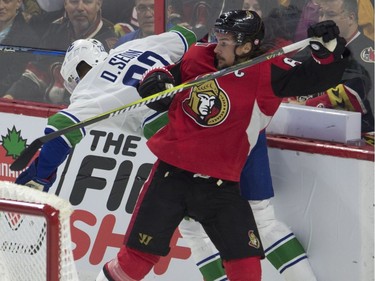 Ottawa Senators defenceman Erik Karlsson, right, collides with Vancouver Canucks left wing Daniel Sedin behind the net during first period NHL action Tuesday, October 17, 2017 in Ottawa.