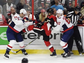 Senators centre Kyle Turris is tied up between the Capitals' Brooks Orpik (44) and Capitals Evgeny Kuznetsov (92) during the first period of Thursday's game. THE CANADIAN PRESS/Adrian Wyld