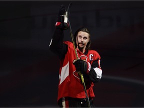 Erik Karlsson acknowledges the home crowd during player introductions before the Senators' regular-season opener on Oct. 5. The team captain has yet to play a game since having foot surgery in the offseason. THE CANADIAN PRESS/Adrian Wyld