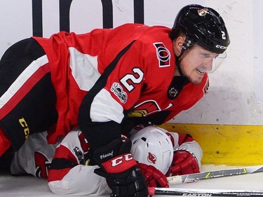 Ottawa Senators defenceman Dion Phaneuf holds New Jersey Devils centre Blake Coleman against the ice.