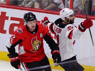 The Devils' Kyle Palmieri celebrates a goal as he skates past Ottawa Senators defenceman Dion Phaneuf during the third period.