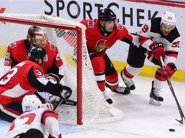Ottawa Senators defenceman Chris Wideman defends as the New Jersey Devils' Brian Gibbons attempts to wrap the puck around the net during the first period.
