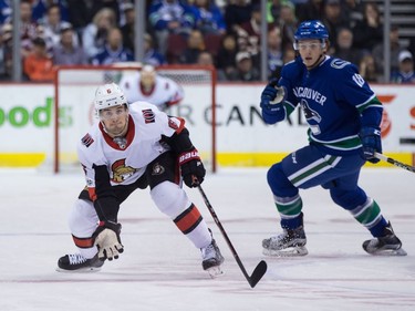 Ottawa Senators' Chris Wideman, left, reaches to catch the puck as Vancouver Canucks' Jake Virtanen watches during first period NHL hockey action in Vancouver on Tuesday, October 10, 2017.