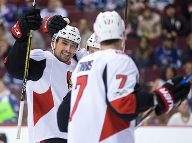 Ottawa Senators' Cody Ceci, left, celebrates his goal with teammate Ryan Dzingel, back right, and Kyle Turris during first period NHL hockey action against the Vancouver Canucks, in Vancouver on Tuesday, October 10, 2017.