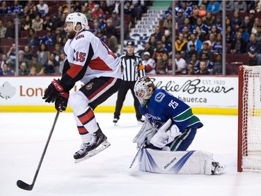 Ottawa Senators' Zack Smith, left, jumps as Vancouver Canucks goalie Jacob Markstrom, of Sweden, makes the save during first period NHL hockey action in Vancouver on Tuesday, October 10, 2017.