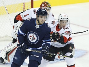 Thomas Chabot, right, attempts to clear the Jets' Marko Dano away from the crease of goaltender Mike Condon during the Senators' Sept. 27 pre-season game at Winnipeg. THE CANADIAN PRESS/John Woods