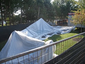 Part of Jill Anholt's sculpture Moving Surfaces sits under a tarp at Lansdowne Park.