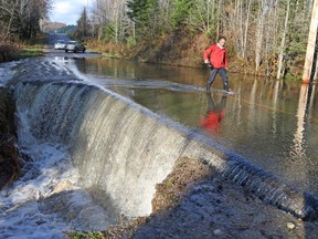 Flood waters erode Chemin de la Montagne near Wakefield on Monday.