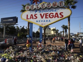 Flowers, candles and other items surround the famous Las Vegas sign at a makeshift memorial for victims of a mass shooting Monday, Oct. 9, 2017, in Las Vegas. Stephen Paddock opened fire on an outdoor country music concert killing dozens and injuring hundreds. (AP Photo/John Locher) ORG XMIT: NVJL208
John Locher, AP