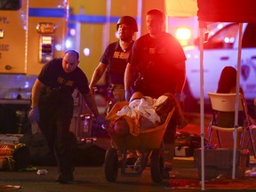 A wounded person is walked in on a wheelbarrow as Las Vegas police respond during an active shooter situation on the Las Vegas Strip Sunday, Oct. 1, 2017.