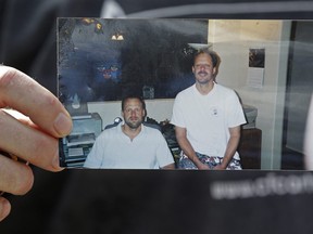 Eric Paddock holds a photo of him, at left, and his brother, Stephen Paddock, at right, outside his home, Monday, Oct. 2, 2017, in Orlando, Fla. Stephen Paddock opened fire on the Route 91 Harvest Festival on Sunday killing dozens and wounding hundreds.