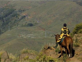 In this file photo, a Lesotho man rides his horse down the valley named God Help Me Pass, 30 miles East of the Capital Maseru.