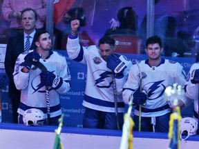Tampa Bay Lightning right wing J.T. Brown, centre, raises his fist in the air during the singing of the national anthem before a game against the Florida Panthers on Oct. 7.