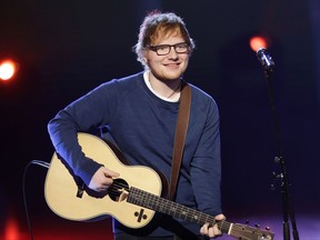 FILE - In this file photo dated Sunday, March 12, 2017, British singer Ed Sheeran performs during the Italian State RAI TV program "Che Tempo che Fa", in Milan, Italy. Sheeran has told fans via Instagram that he's had a bicycle injury and posted a photo of his arm in a cast, advising fans he may have to change some concert dates with a series of shows in Asia scheduled to start on Oct. 22. (AP Photo/Antonio Calanni, FILE)