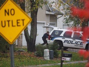 Portage police search Christopher Lockhart's home, where he was found dead, Tuesday, Oct. 24, 2017. Police believe he killed himself. Lockhart, 47, was a person on interest involving the mid-May disappearance of his wife, Theresa Lockhart, a Schoolcraft High School teacher. He had denied any role in his wife's disappearance. (Mark Bugnaski/Kalamazoo Gazette-MLive Media Group via AP)