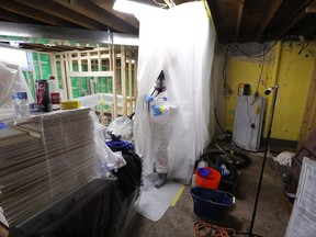 In this July 12, 2017, photo, Asbestos Removal Technologies Inc., job forman Megan Eberhart prepares for asbestos abatement in Howell, Mich. Spurred by the chemical industry, President Donald Trump's administration is retreating from a congressionally mandated review of some of the most dangerous chemicals in public use. The review began under Trump's predecessor to make sure proper safeguards are in place for asbestos and other toxins in homes, offices and industrial plants across the United States. (AP Photo/Paul Sancya)