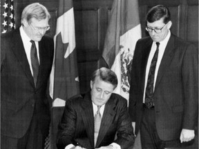 Prime Minister Brian Mulroney, in 1992, signs the North American Free Trade Agreement, witnessed by Trade Minister Michael Wilson, left, and negotiator John Weekes.