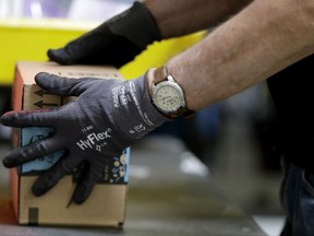 An employee packages a product at an Amazon Fulfillment center.