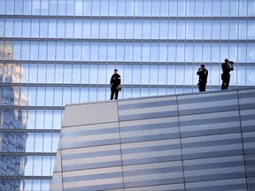 FILE - In this Sept. 27, 2014 file photo, a sniper team stands watch during a visit by the prime minister of India to the National September 11 Memorial, in New York. A Las Vegas shooting from a high-rise hotel that killed dozens of people in a packed concert below on Sunday, Oct. 1, 2017, has forced other cities to examine their tactics for dealing with this kind of nightmare scenario. In New York, which hosts Times Square New Year's Eve and other events surrounded by high-rises, police say they use rooftop snipers to scan for threats, and make security sweeps of nearby hotels. (AP Photo/Jason DeCrow, File)
