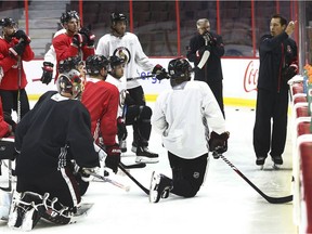 Senators head coach Guy Boucher, right, talks to his players during a practice on Monday.  Tony Caldwell/Postmedia