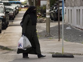 A woman wears a niqab as she walks. None of the five candidates running for mayor in Gatineau agree with Quebec's controversial face-covering ban.
