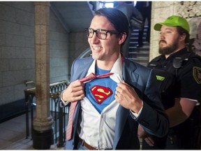 Prime Minister Justin Trudeau shows off his costume as Clark Kent, alter ego of comic book superhero Superman, as he walks through the House of Commons, in Ottawa on Tuesday, October 31, 2017.