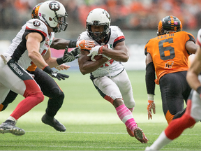 The Ottawa Redblacks' William Powell carries the ball past the B.C. Lions' T.J. Lee during the first half in Vancouver on Saturday, Oct. 7, 2017.
