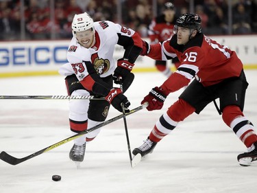 Senators winger Jack Rodewald, playing his first NHL game, and Devils defenceman Steven Santini compete for the puck during the first period. AP Photo/Julio Cortez