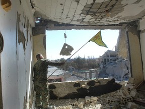 A Syrian Democratic Forces (SDF) fighter, waves his Kurdish party flag at the front line of the battle against the Islamic State militants, in Raqqa, Syria, Oct. 16, 2017.