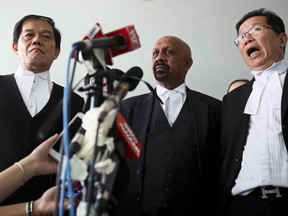 Hisyam Teh Poh Teik, left, Naran Singh, center, lawyers for Vietnamese Doan Thi Huong, and Gooi Soon Seng, lawyer for Indonesian Siti Aisyah, talk to media after court hearing this morning at Shah Alam court house in Shah Alam, outside Kuala Lumpur, Malaysia Wednesday, Oct. 11, 2017. Security videos showing the estranged half brother of North Korea's leader being attacked at a Malaysian airport and the two suspects hurrying away afterward were presented at their murder trial Wednesday. Kim Jong Nam was seen arriving at the airport the morning of Feb. 13 and moving to a check-in area. One woman clasps both hands on his face from behind, and both suspects hurry to restrooms afterward.(AP Photo/Sadiq Asyraf)