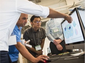Algonquin College student, Shadi Al Khalil, checks out Dancing Data, while Weikai Li, second from right, looks on during the presentations at Applied Research Day at the Bayview Innovation Yards in Ottawa Friday, August 18, 2017.