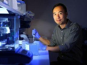Paul Lem, CEO of Spartan Bioscience Inc. in Ottawa, sits beside the tiny square machine the local company has developed that analyzes DNA. It is the world's smallest DNA analyzer.