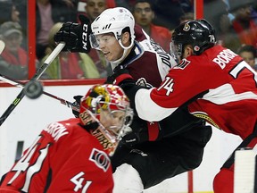 Mark Borowiecki (R) keeps control of Matt Duchene while goalie Craig Anderson watches where the puck goes.