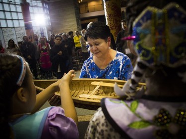 Claudette Commanda, Algonquin Anishinabe from Kitigan Zibi Anishinabeg First Nation, walks around a circle of children as they place tobacco into a hand-made canoe during a canoe-raising ceremony.  Ashley Fraser/Postmedia