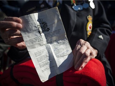 William McLachlan holds the poem "You Bought Me Time" during the National Remembrance Day Ceremony at the National War Memorial in Ottawa on Saturday, November 11, 2017.
