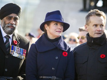 Sophie Gregoire Trudeau, wife of Prime Minister Justin Trudeau (middle) along with L-R Minister of National Defence Harjit Sajjan and Minister of Veterans Affairs and Associate Minister of National Defence Seamus O'Regan watch the march during the National Remembrance Day Ceremony at the National War Memorial in Ottawa on Saturday, November 11, 2017.