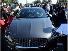 David Van Geyn (right), from Blackberry QNX, holds up his hands to demonstrate the driverless vehicle he took Ottawa mayor Jim Watson and others for a test ride at the Kanata North Technology Park.