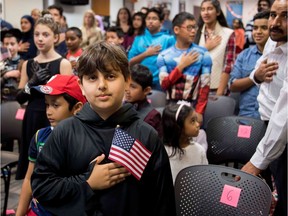 A young boy recites the U.S. Pledge of Allegiance at a citizenship ceremony. Readers are interested in the Canadian pledge.