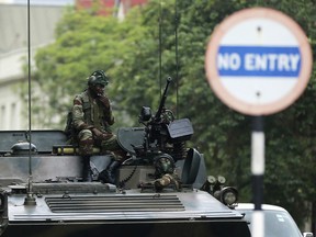 Soldiers sit on a military vehicle parked on a street in Harare, Zimbabwe, Thursday, Nov. 16, 2017.
