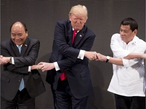 Donald Trump, Rodrigo Duterte, Nguyen Xuan Phuc

CORRECTS ID TO VIETNAMESE PRIME MINISTER NGUYEN XUAN PHUC - U.S. President Donald Trump, center, reacts as he does the "ASEAN-way handshake" with Vietnamese Prime Minister Nguyen Xuan Phuc, left, and Philippines President Rodrigo Duterte on stage during the opening ceremony at the ASEAN Summit at the Cultural Center of the Philippines, Monday, Nov. 13, 2017, in Manila, Philippines. Trump initially did the handshake incorrectly. Trump is on a five-country trip through Asia traveling to Japan, South Korea, China, Vietnam and the Philippines. (AP Photo/Andrew Harnik) ORG XMIT: PHIH107

CORRECTS ID TO VIETNAMESE PRIME MINISTER NGUYEN XUAN PHUC
Andrew Harnik, AP