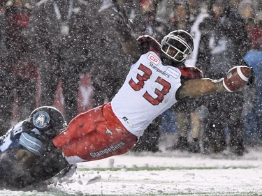 Calgary Stampeders running back Jerome Messam (33) is tackled by Toronto Argonauts linebacker Terrance Plummer (47) as he scores a touchdown during first half CFL football action in the 105th Grey Cup on Sunday, November 26, 2017 in Ottawa.