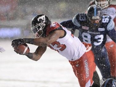 Calgary Stampeders running back Jerome Messam (33) dives into the end zone for a touchdown ahead of Toronto Argonauts defensive tackle Linden Gaydosh (93) during first half CFL football action in the 105th Grey Cup Sunday November 26, 2017 in Ottawa.