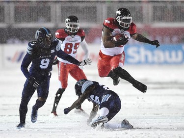 Calgary Stampeders running back Jerome Messam (33) jumps over Toronto Argonauts defensive back Cassius Vaughn (26) as Argonauts defensive back Akwasi Owusu-Ansah (9) looks on during first half CFL football action in the 105th Grey Cup on Sunday, November 26, 2017 in Ottawa.